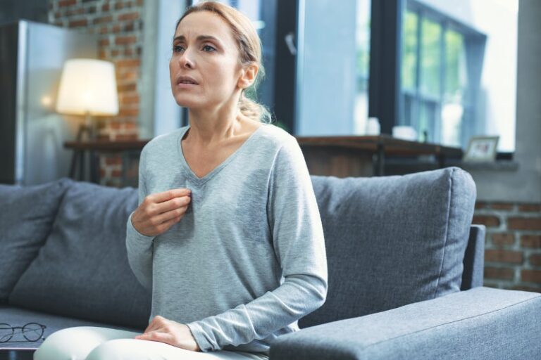 woman feeling warm in her home pulling at shirt