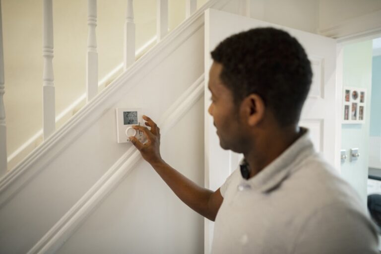 man pressing thermostat