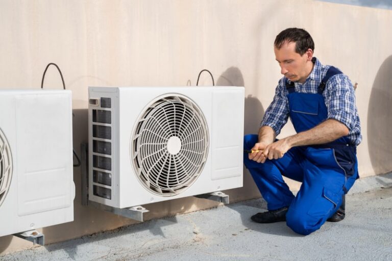 man works on ac unit