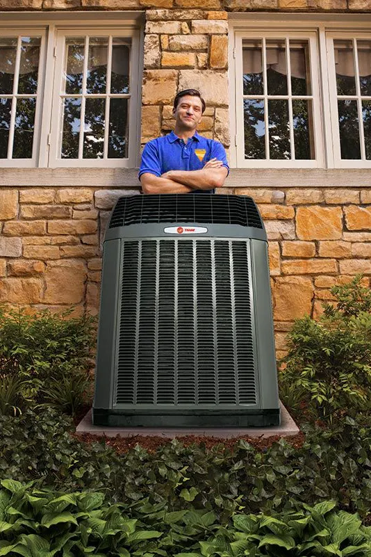 trane dealer standing behind ac unit